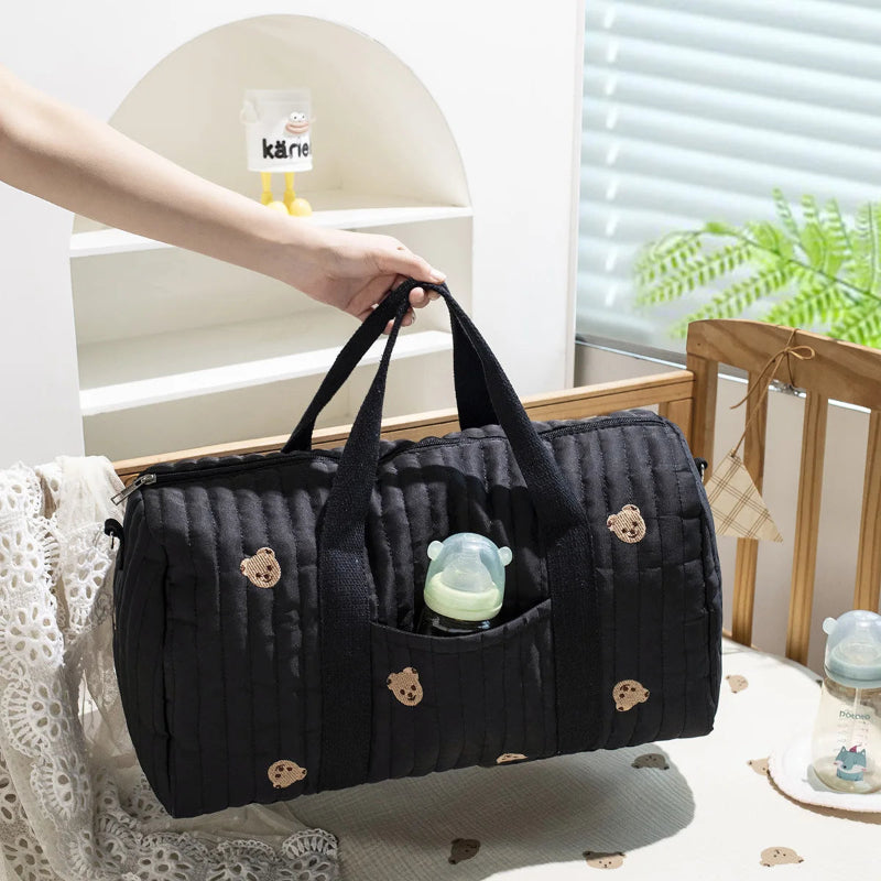 Grand sac à langer noir motif ourson dans lit bébé