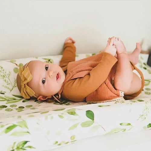 Matelas à langer fleuris vert avec bébé
