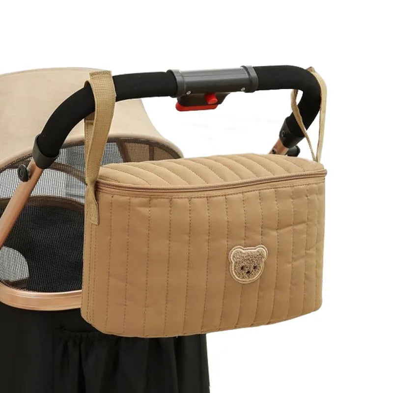 Mini sac à langer marron suspendu à une poussette