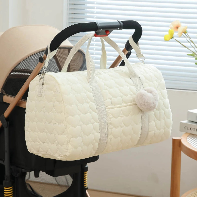 Grand sac à langer beige suspendu à une poussette