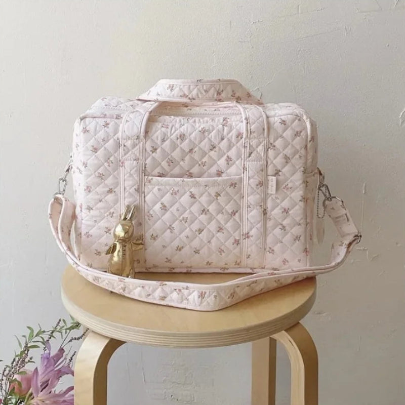 Sac à langer bébé rose sur un tabouret
