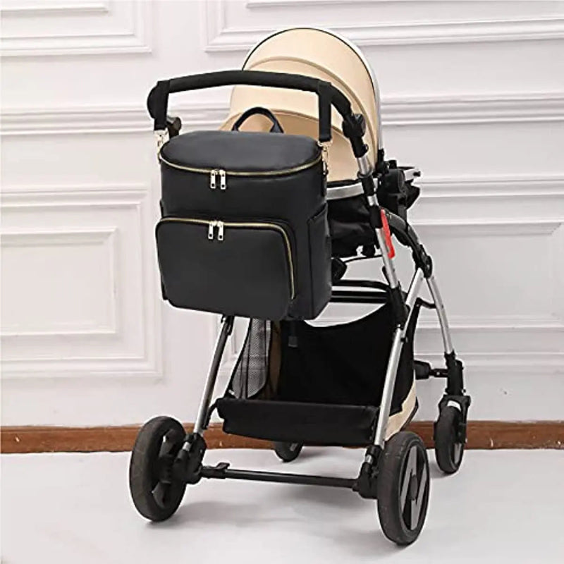 Sac à langer en cuir noir suspendu à une poussette