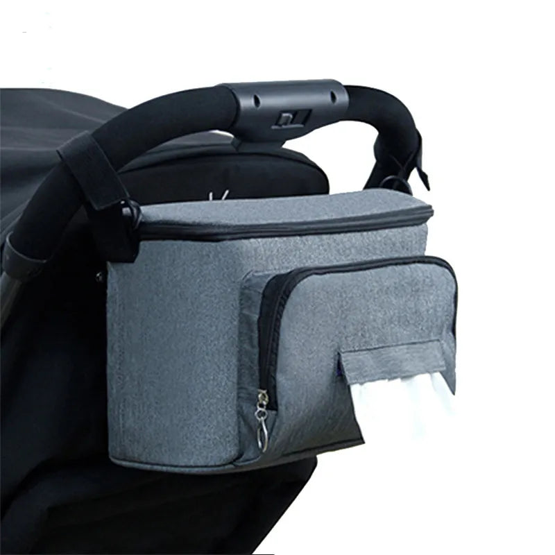 Sac à langer poussette gris accroché à une poussette